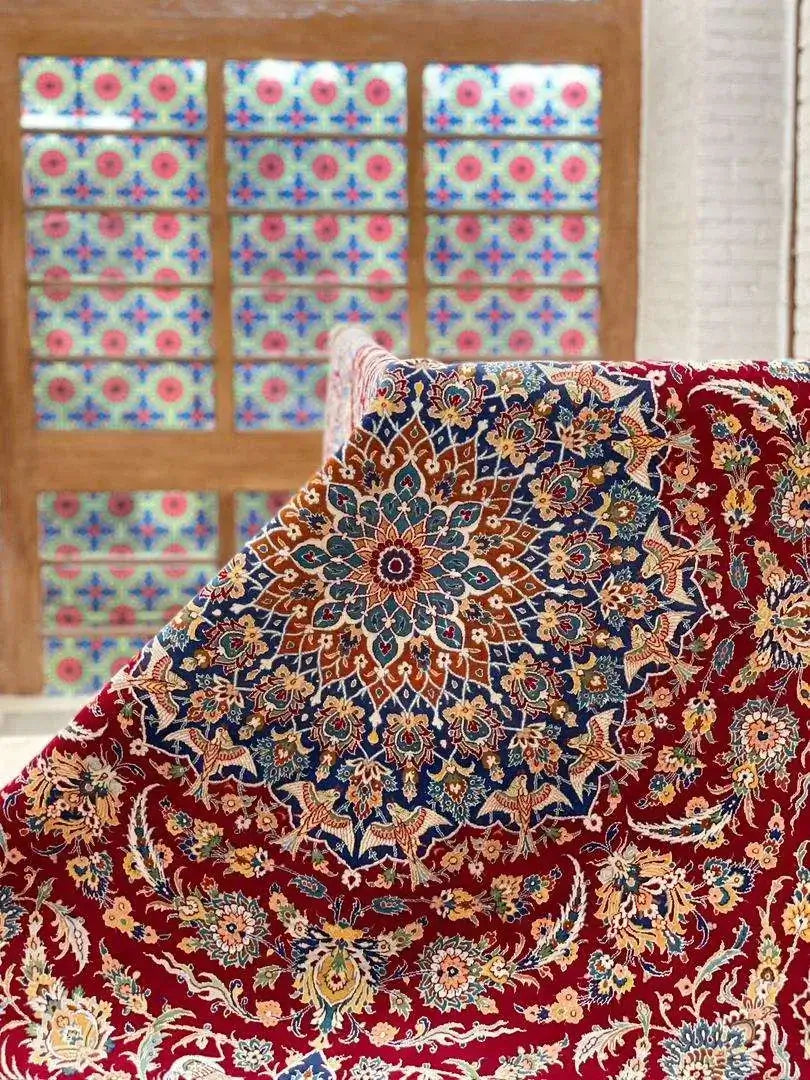 Luxurious Isfahan Persian carpet displayed on a table with red and blue patterns