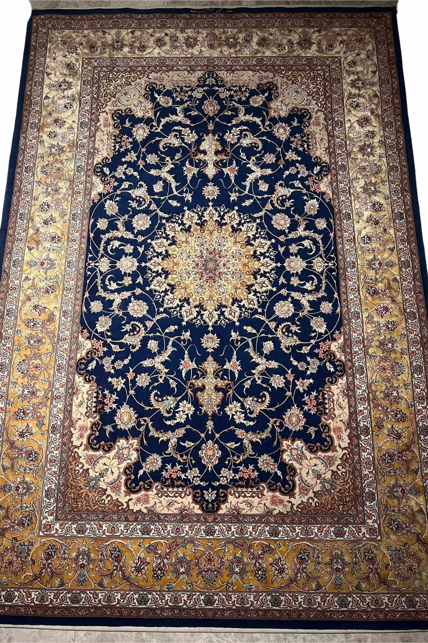 "Handmade Isfahan rug with a rich navy blue base, golden arabesque designs, and luxurious silk highlights."