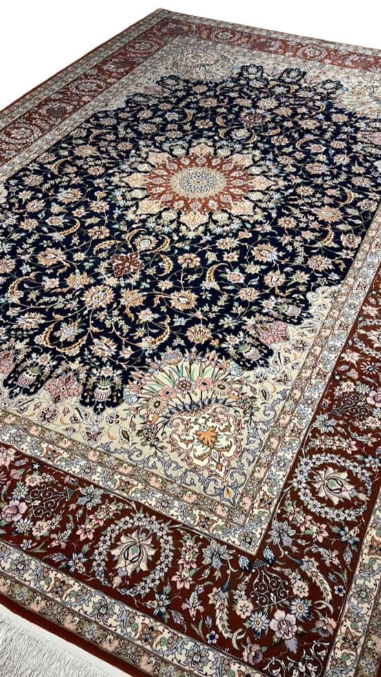 "Authentic Persian carpet from Isfahan, Iran, featuring a navy blue background and elaborate floral motifs."