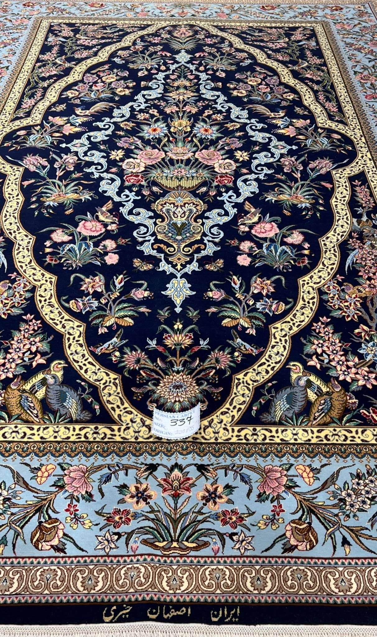 "Traditional Persian wool and silk rug with gold-accented scalloped border, crafted by Kheirie."
