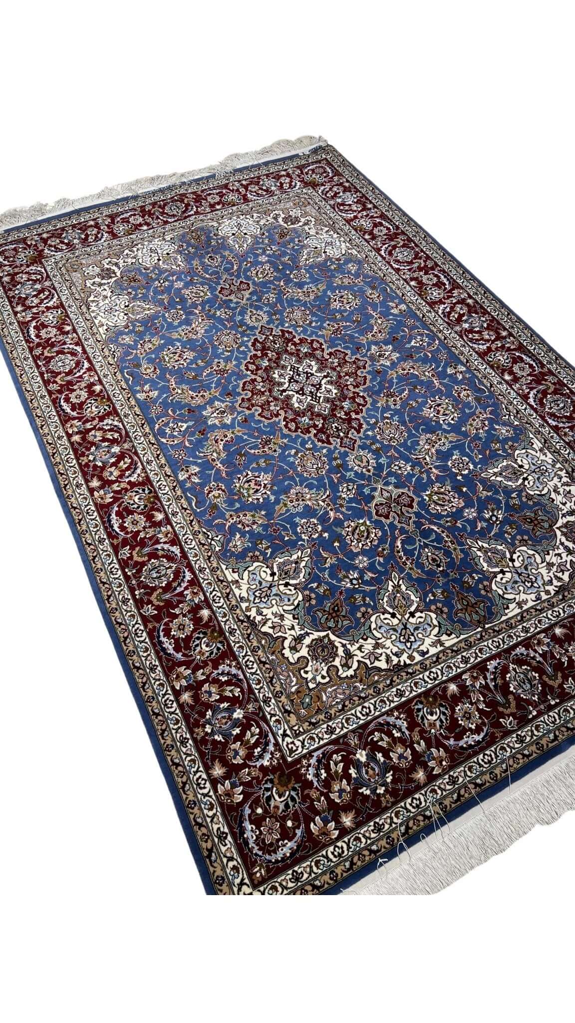 "Detail of traditional Persian motifs in hand-knotted Isfahan rug, crafted by master weaver Hossein Davarie."
