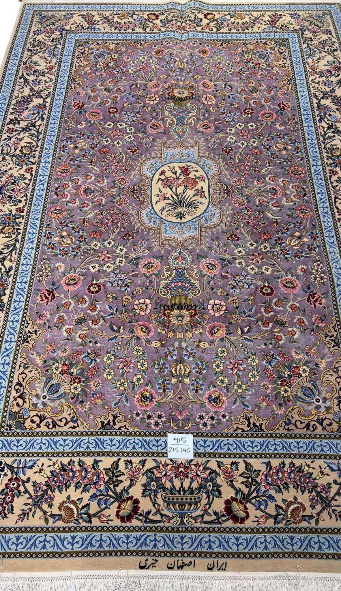 "Elegant Persian rug with intricate floral motifs on a lilac base, hand-knotted by Kheire, 215 x 140 cm."
