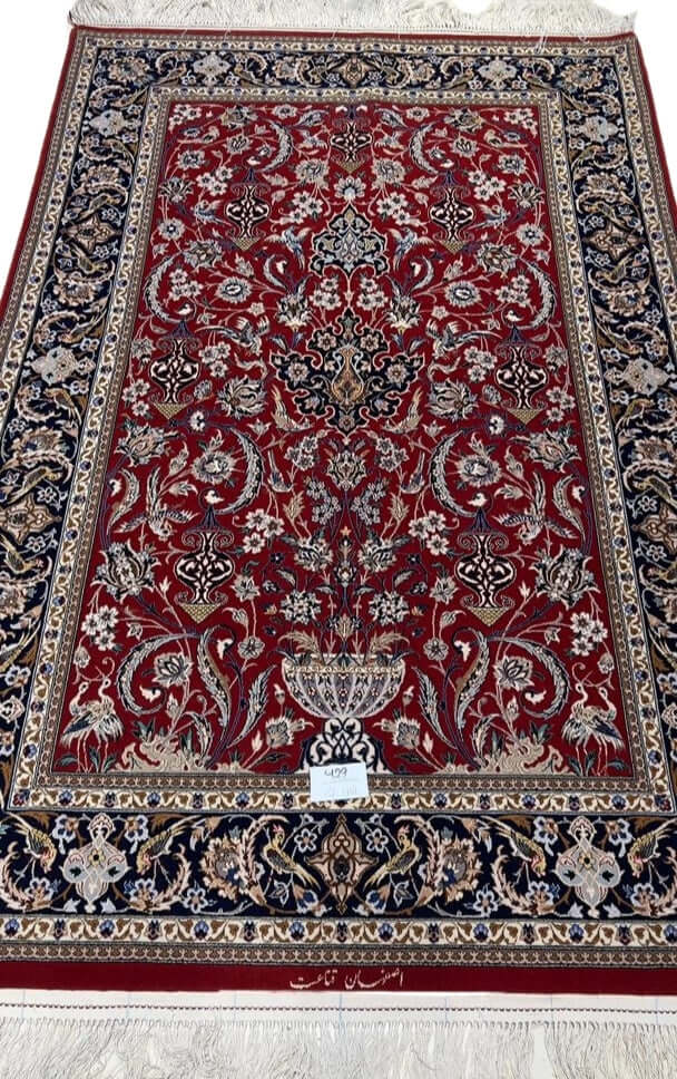 "Hand-knotted Isfahan Persian rug crafted by Ghenaat, featuring wool and silk in a luxurious red and black design. Measuring 170 cm x 110 cm (5.6 ft x 3.6 ft) with a knot density of 810,000 knots per square meter, this exquisite Persian carpet showcases intricate craftsmanship. Available for purchase online with only one rug in stock."
