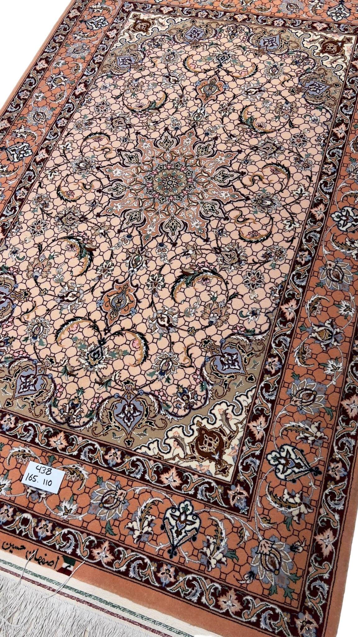 Elegant Isfahan rug featuring a central medallion and soft peach background.
