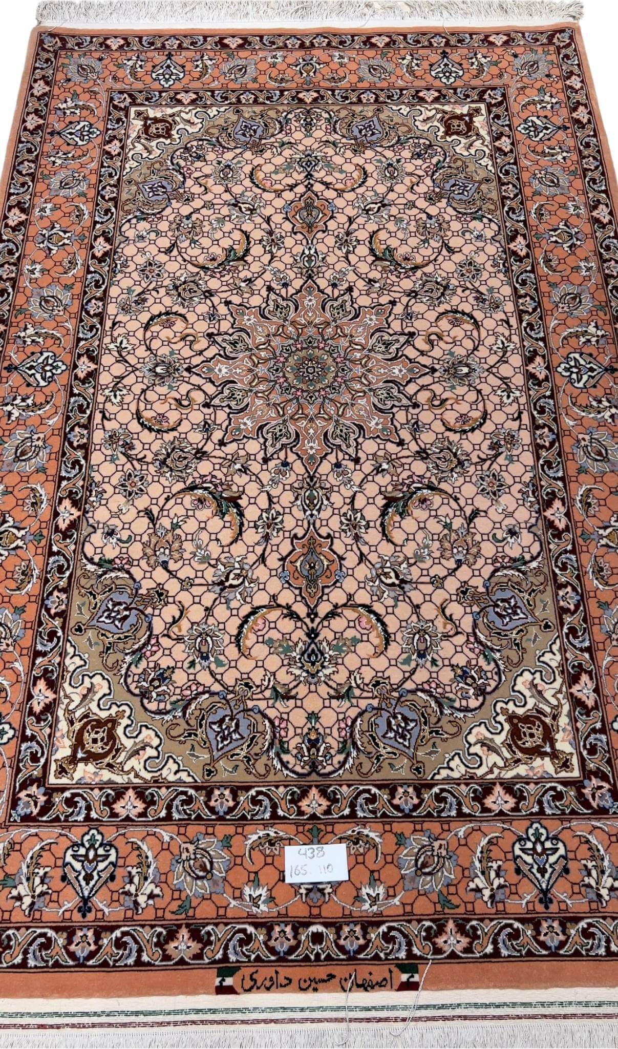 Hand-knotted Persian rug from Isfahan with peach tones and floral motifs.
