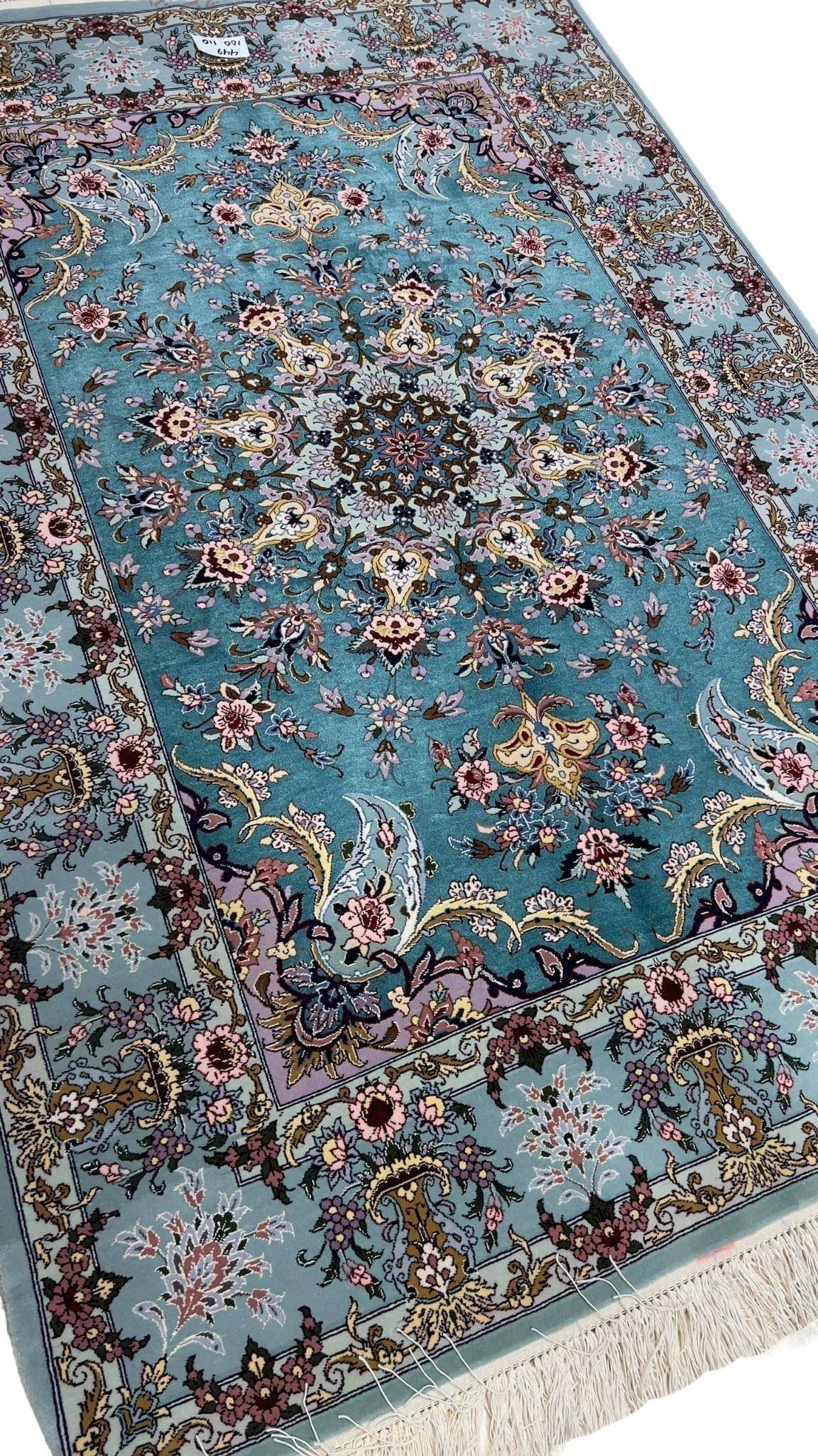 Luxurious wool and silk Persian rug featuring a teal and light blue color scheme.
