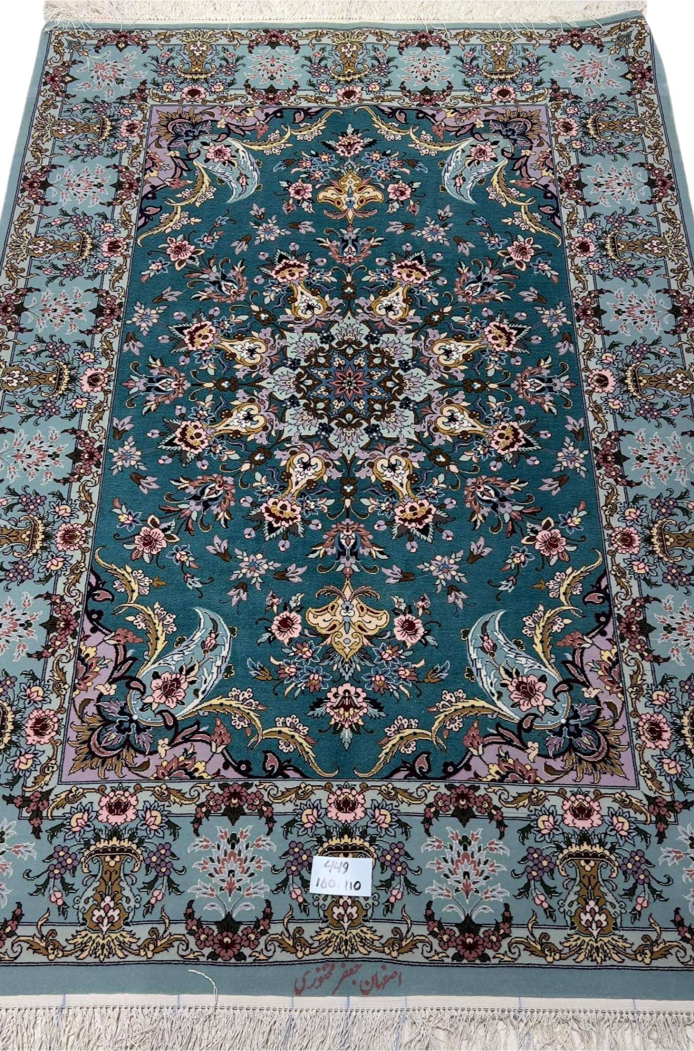 Hand-knotted Isfahan Persian rug with teal background and floral medallion.
