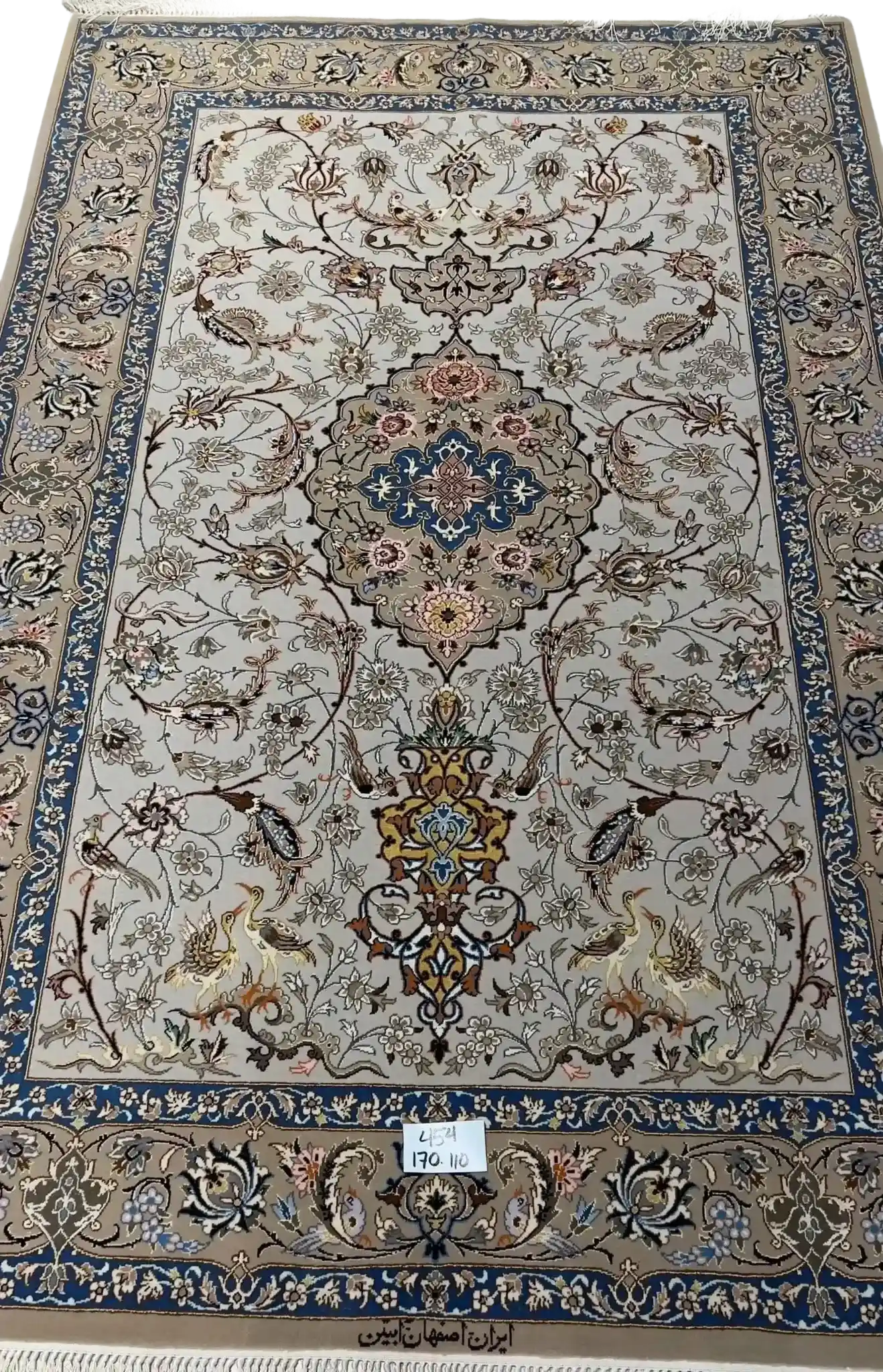 "Light grey Persian Isfahan rug, handcrafted using wool and silk. Elegant designer area rug with intricate details, measuring 170 cm x 110 cm. High knot density for added comfort and beauty."