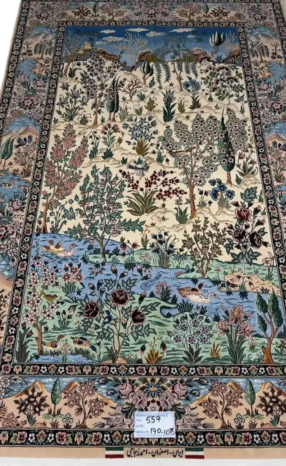 "Luxury Persian carpet from Isfahan, Iran, made of silk and wool with floral, river, and wildlife motifs."