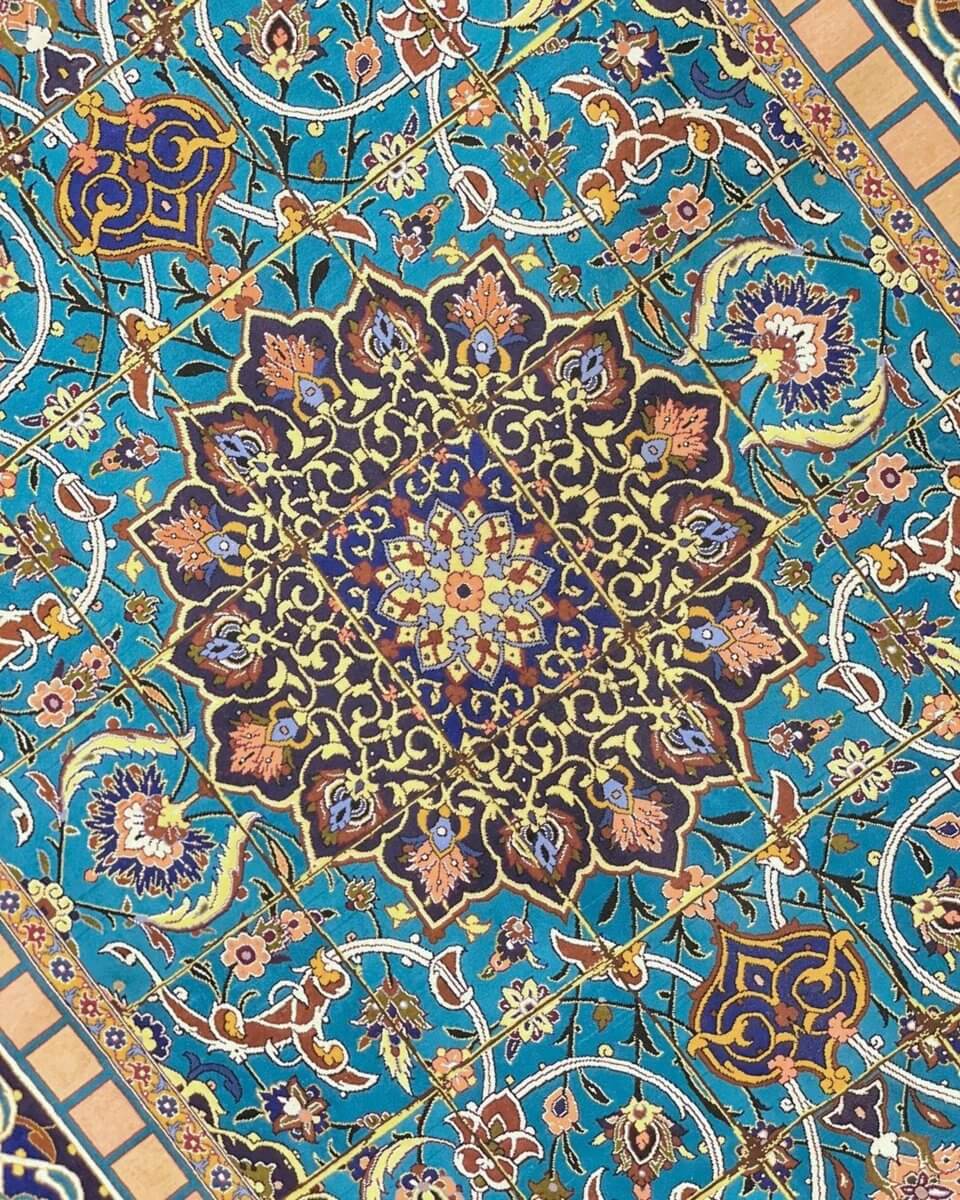 "Close-up view of the hand-knotted Isfahan rug, highlighting the detailed patterns and silk warp."