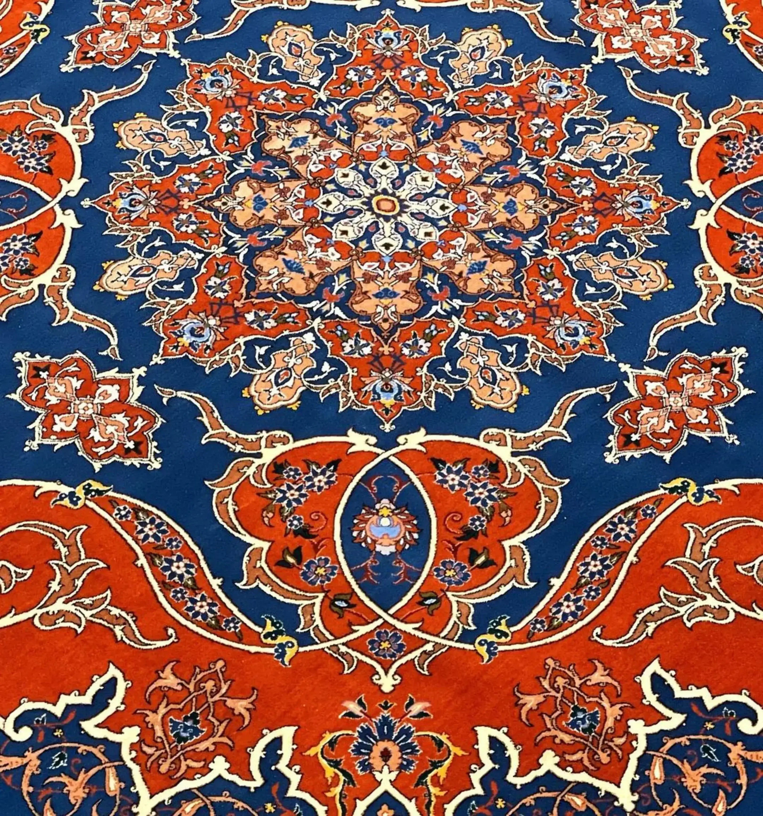 Hand-knotted Persian rug in a bold orange and blue palette, showcasing traditional Isfahan artistry.
