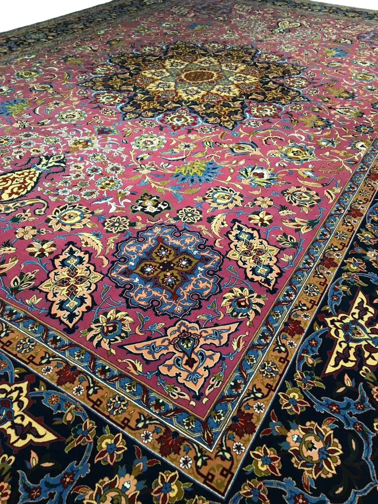 Close-up of the floral motifs and knot details on the purple area rug, showcasing a harmonious blend of purple, blue, and gold tones.
