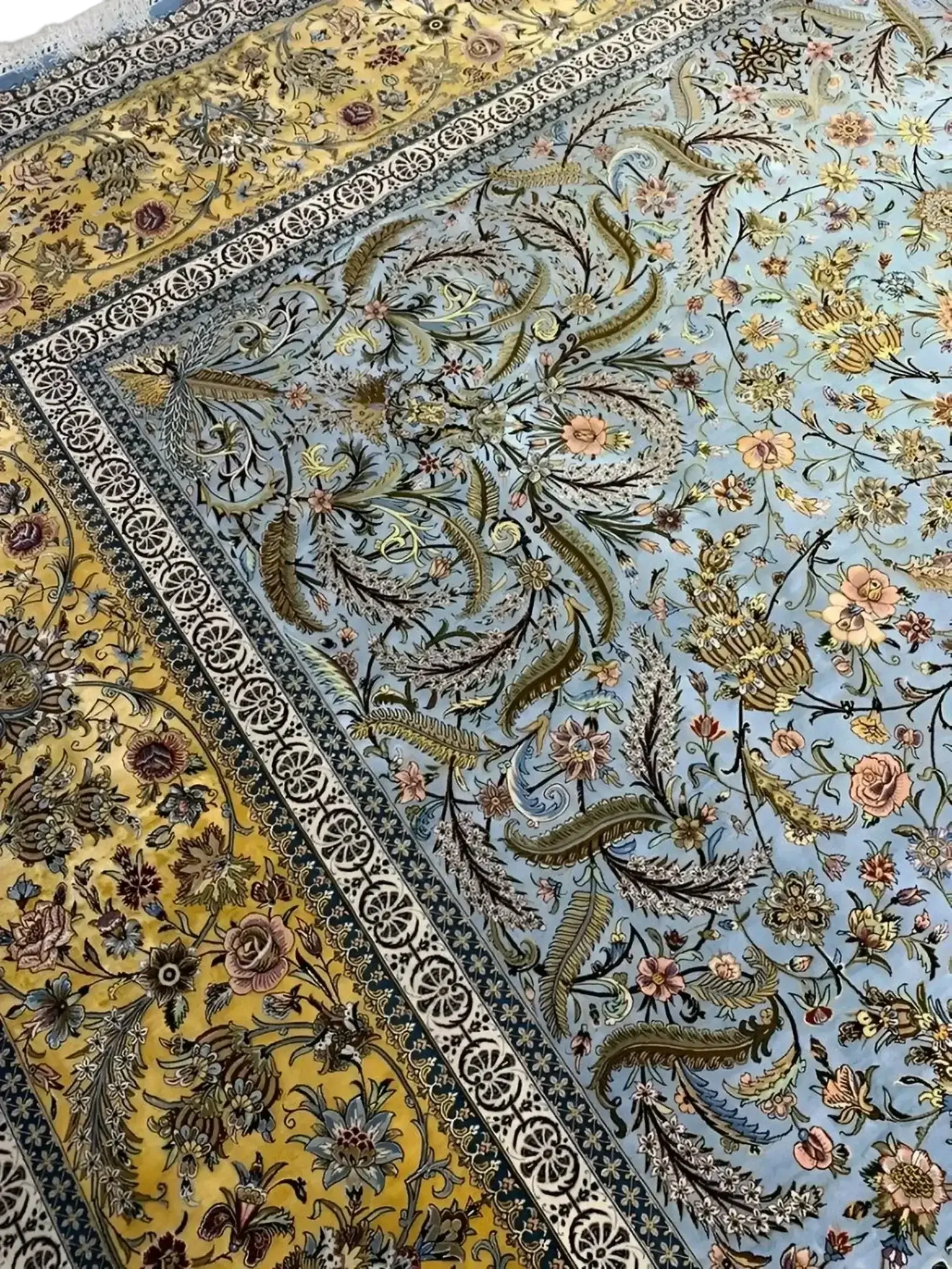 "Elegant hand-knotted Persian rug with a beautiful mix of blue and yellow hues, highlighting traditional motifs from Iranian carpet-making heritage."