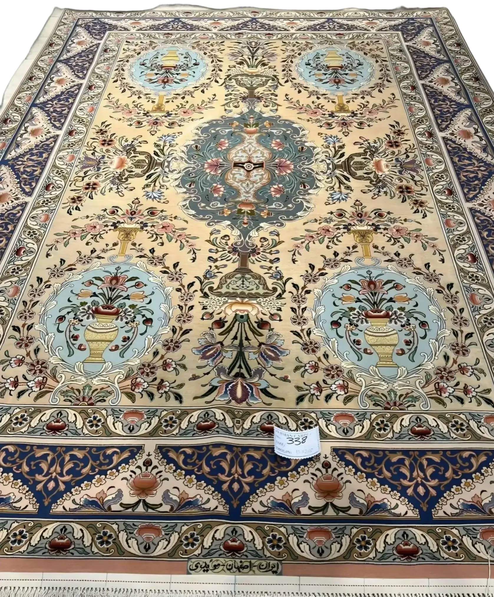 "Handmade Persian rug by Master Moeidie with intricate floral designs in soft beige and pastel tones."
