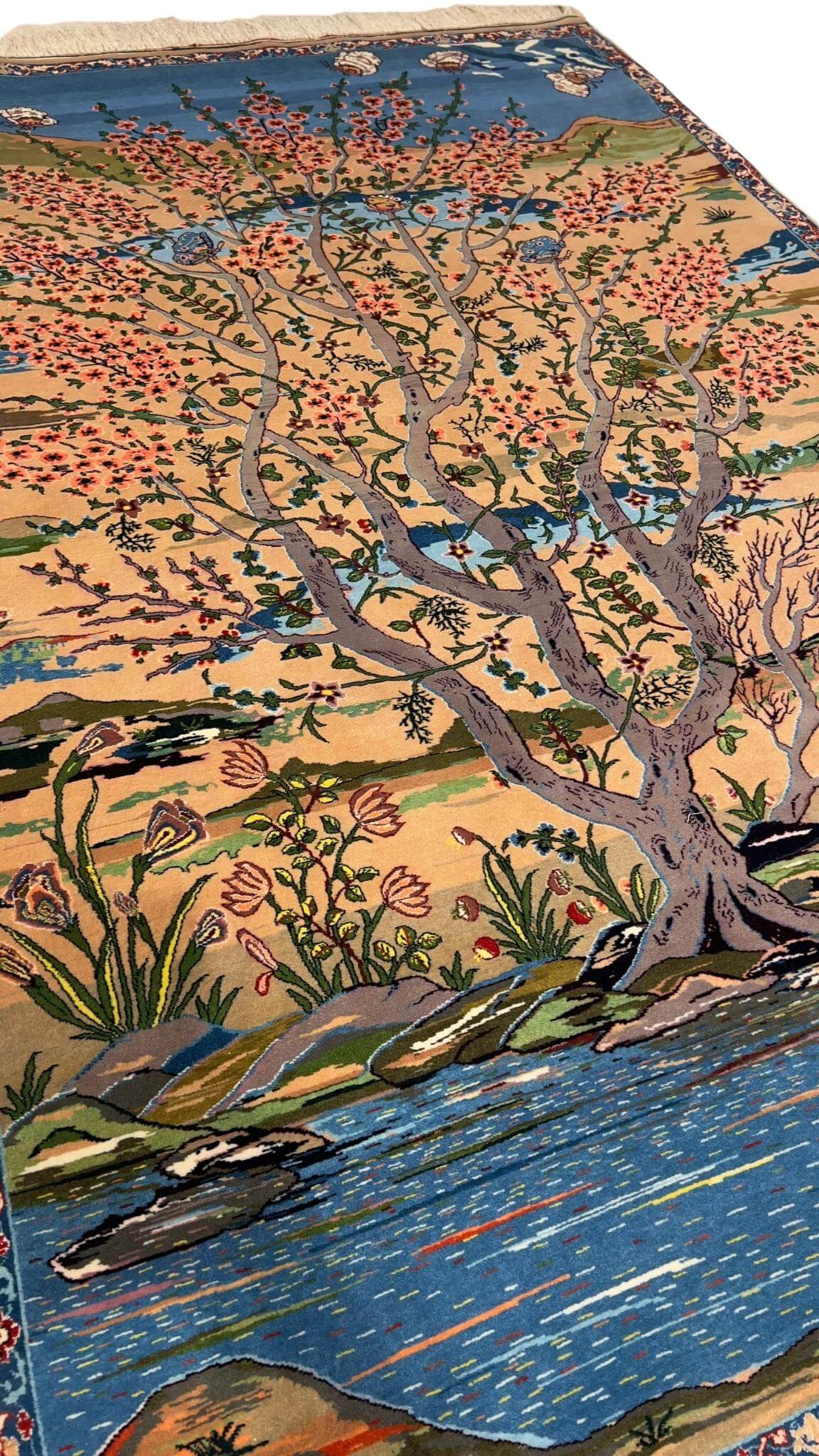 "Artisan-crafted Persian rug with vibrant tree and floral patterns in natural dyes."
