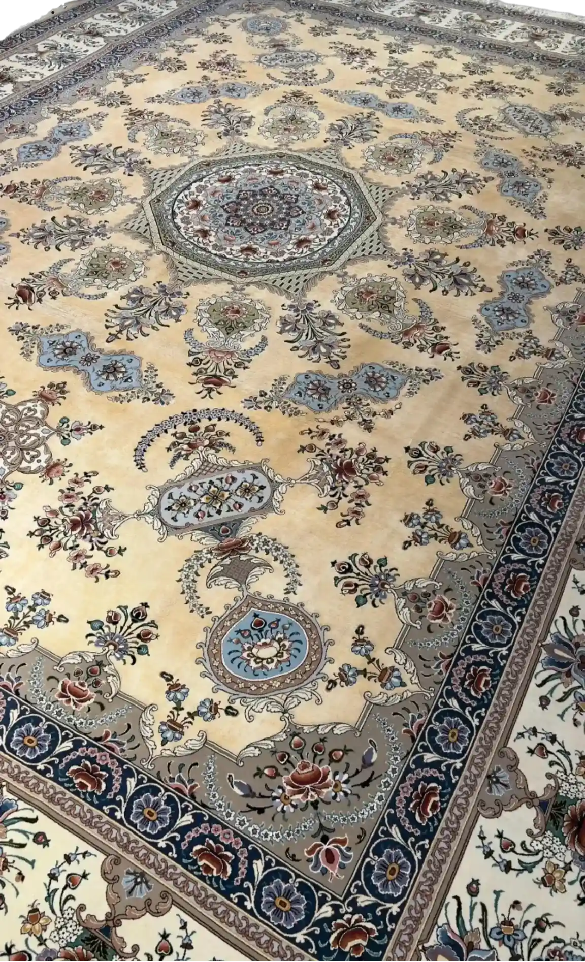 Elegant Persian Isfahan rug in soft beige and blue hues, detailed with a central medallion and bordered with floral motifs.
