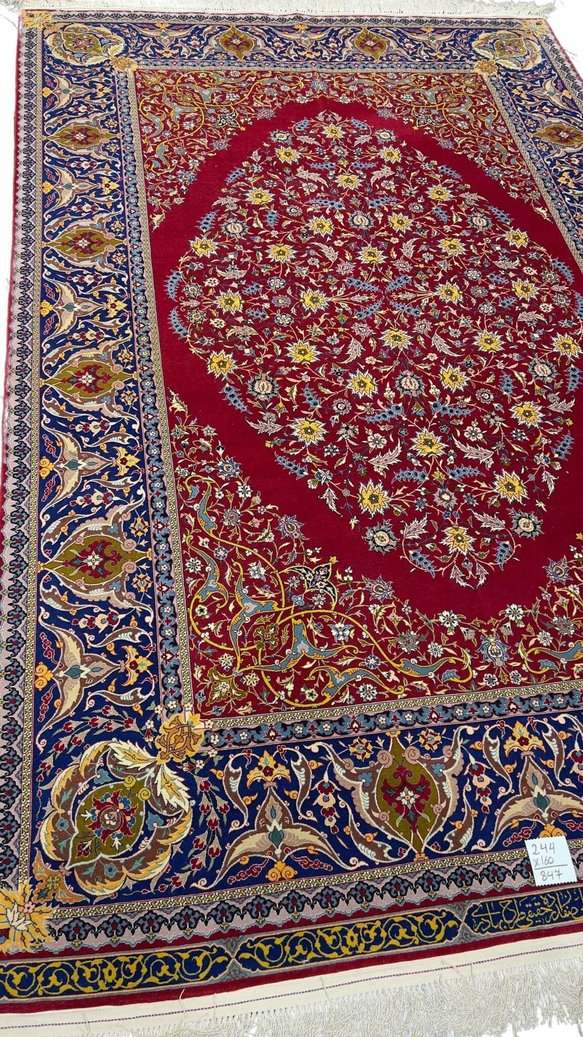 "Master Haghieghie’s handwoven red Persian rug with silk and wool pile"
