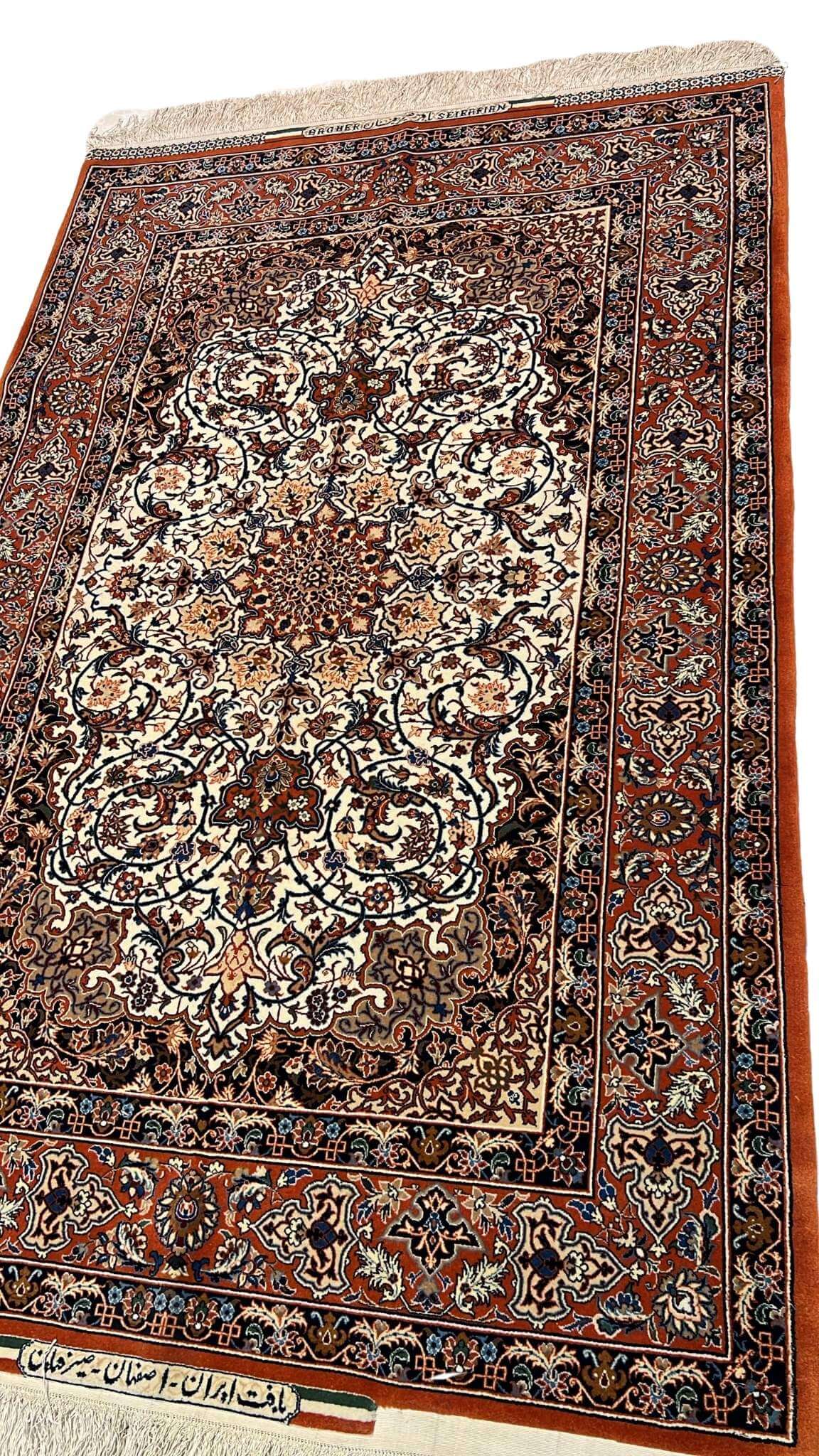 "Close-up of a hand-knotted Master Bagher Seirafian collectible rug, showcasing Persian craftsmanship with natural dyes in a floral pattern."
