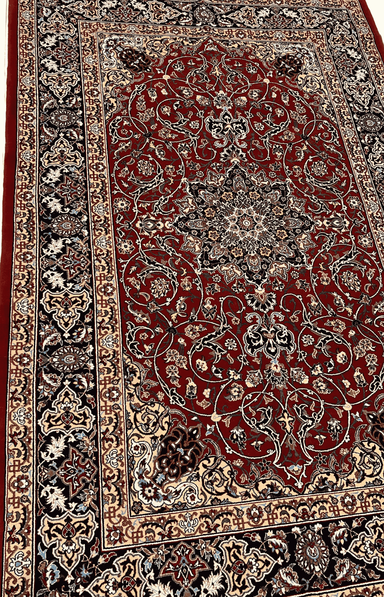 "Close-up of a hand-knotted Seirafian Persian rug, showcasing intricate floral and medallion designs in red, blue, and beige, made from silk and wool."

