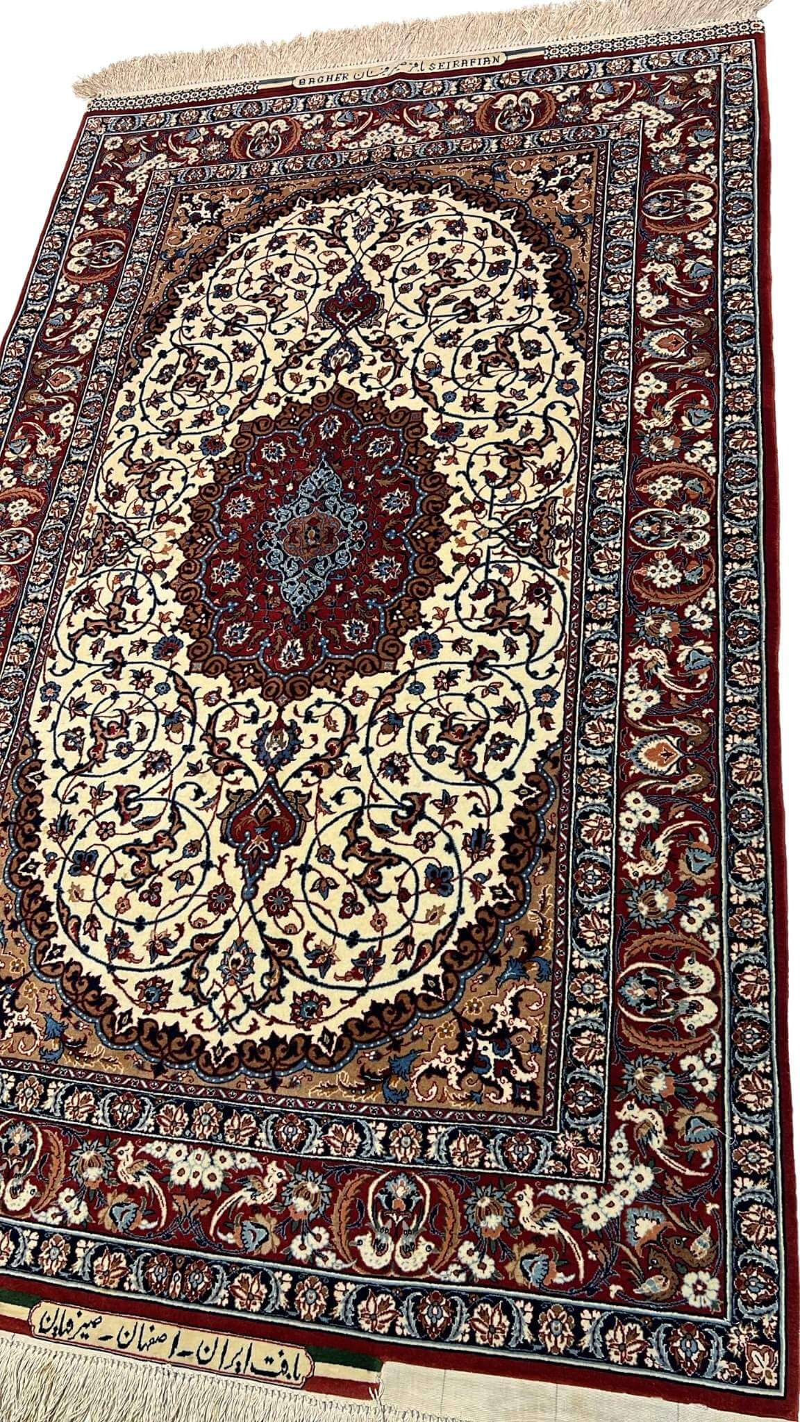 "Close-up view of a handmade Seirafian Persian rug, showing the fine knotting, luxurious wool and silk blend, and floral motifs."

