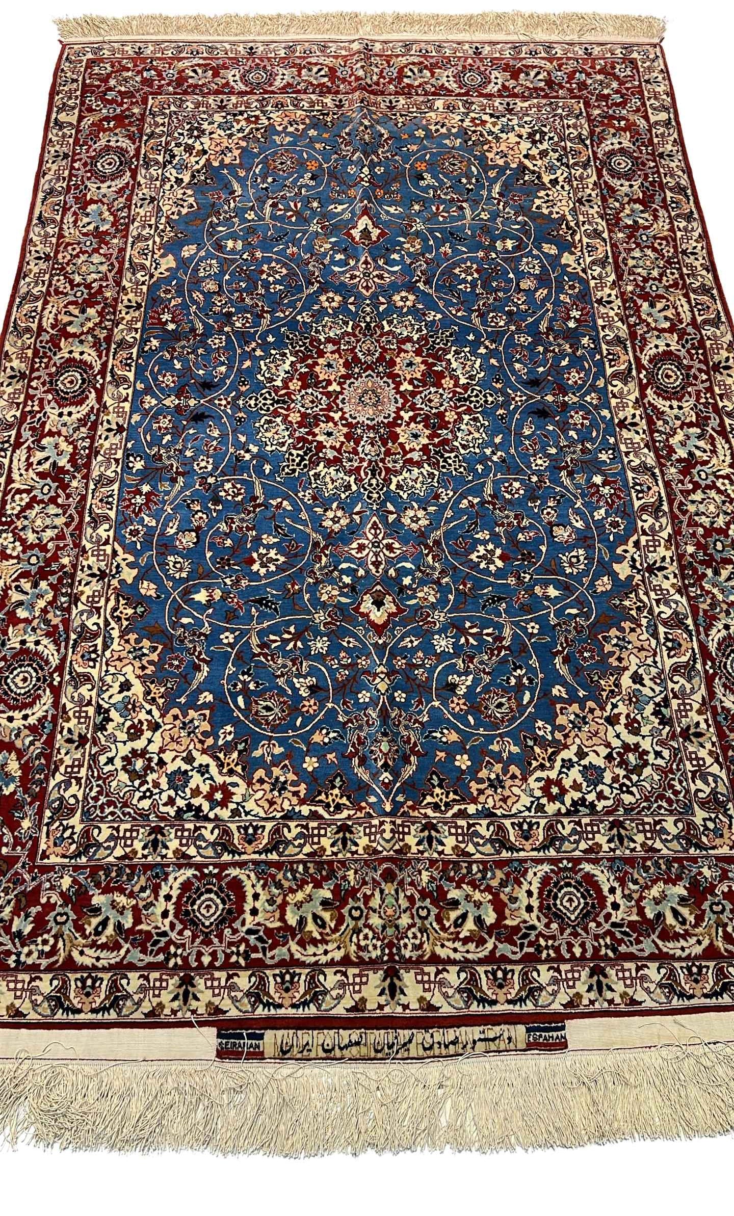 "Hand-knotted vintage Seirafian Persian rug by Master Sadegh Seirafian, featuring intricate floral patterns in blue, red, and ivory, crafted in Isfahan."
