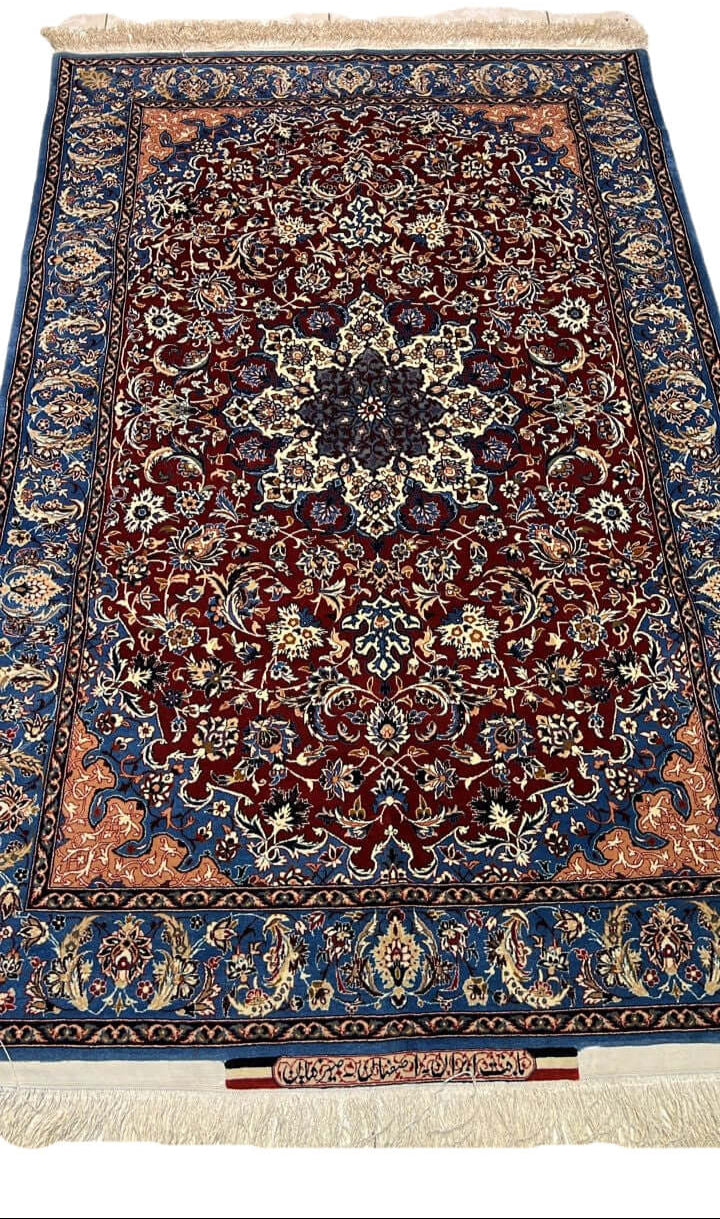 "Handwoven Seirafian silk carpet with floral design, crafted by Master Ahmad Seirafian in Isfahan, featuring intricate patterns in silk and wool."
