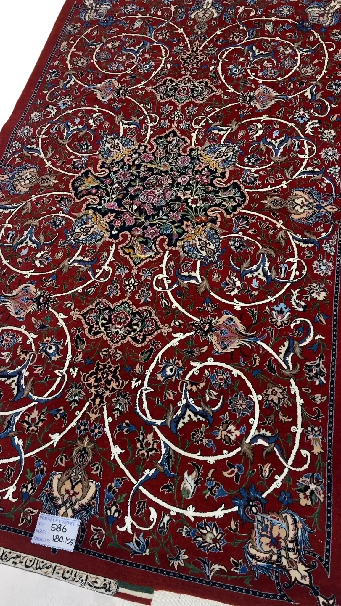 "Hand-knotted Isfahan Persian rug by renowned weaver Bagher Seirafian. Dimensions are 189 x 105 cm (approximately 6.2 x 3.4 feet) with a 5 mm thickness and a high knot density of 1,210,000 knots per square meter. The rug features a vibrant red floral design crafted from a wool and silk pile with a silk warp. This exclusive and new rug weighs 5 kg and is available for purchase."