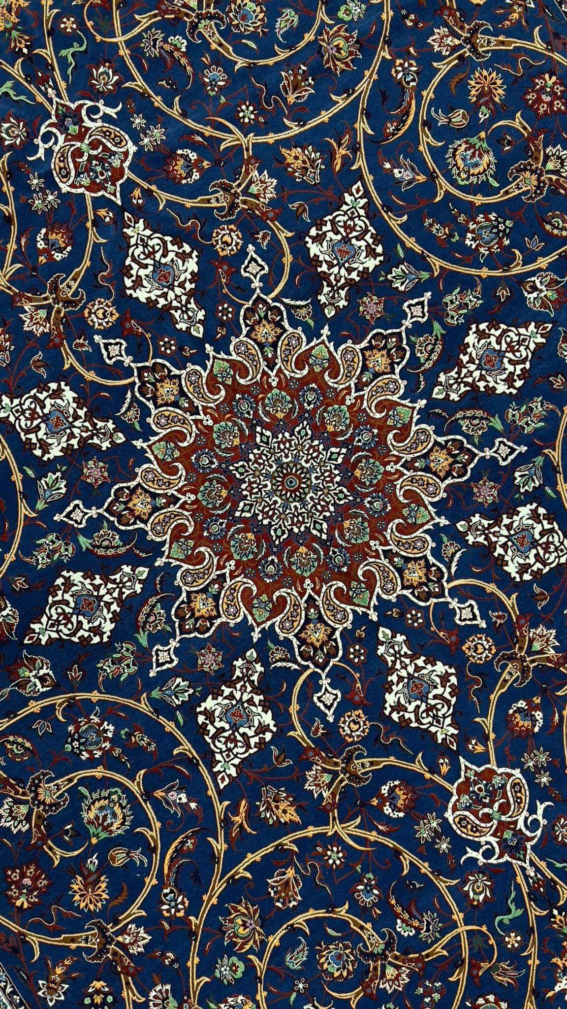 "Close-up of intricate paisley and floral motifs on a silk and wool Persian rug."
