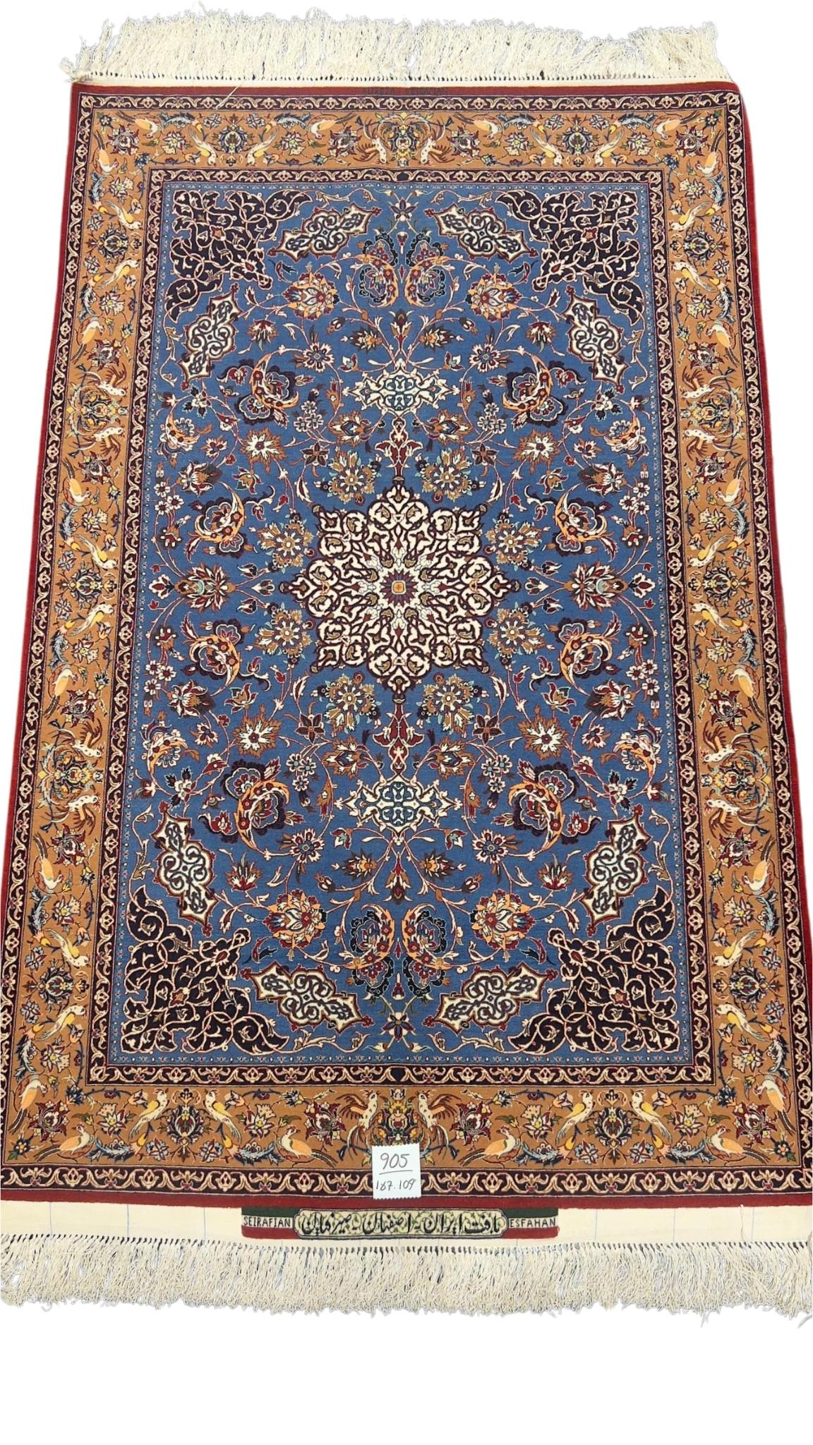 Hand-knotted Seirafian rug in blue and gold with intricate floral patterns.
