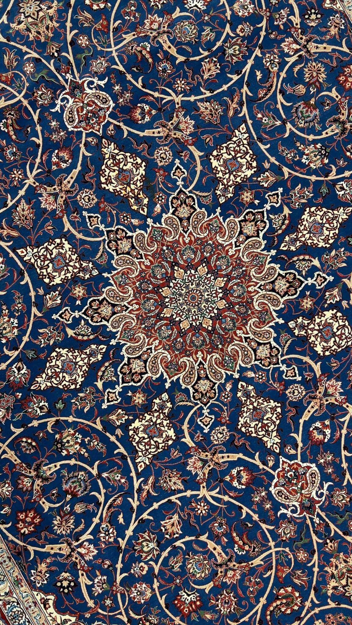 "Close-up of the intricate medallion design on a handwoven silk and wool Persian rug."
