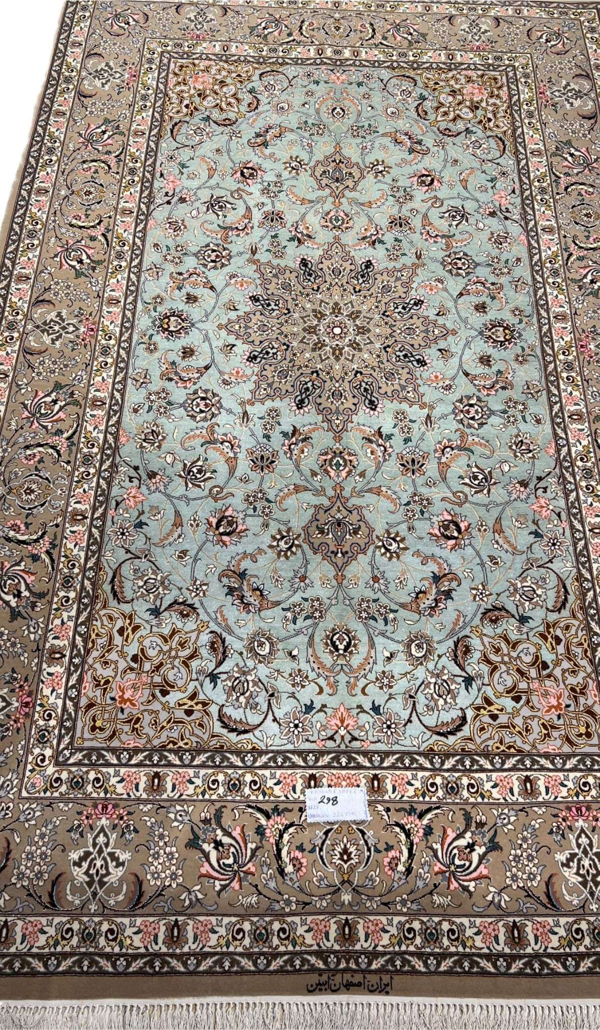 Hand-knotted Isfahan rug with a mint-green base and floral medallion.
