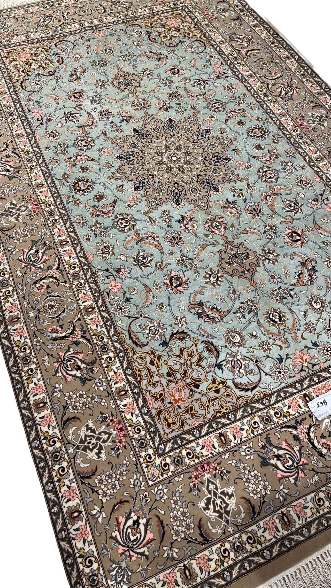 Persian rug featuring a central medallion and beige floral borders.

