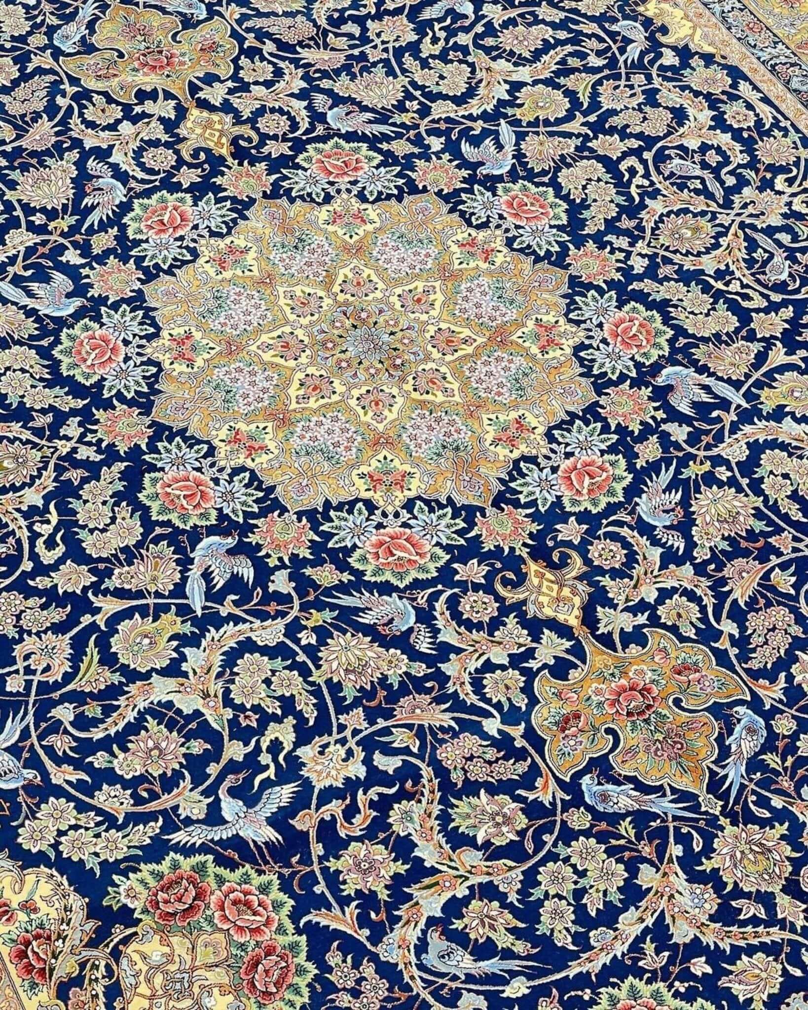 "Elegant navy blue Persian rug with intricate floral patterns and silk accents, hand-knotted."
