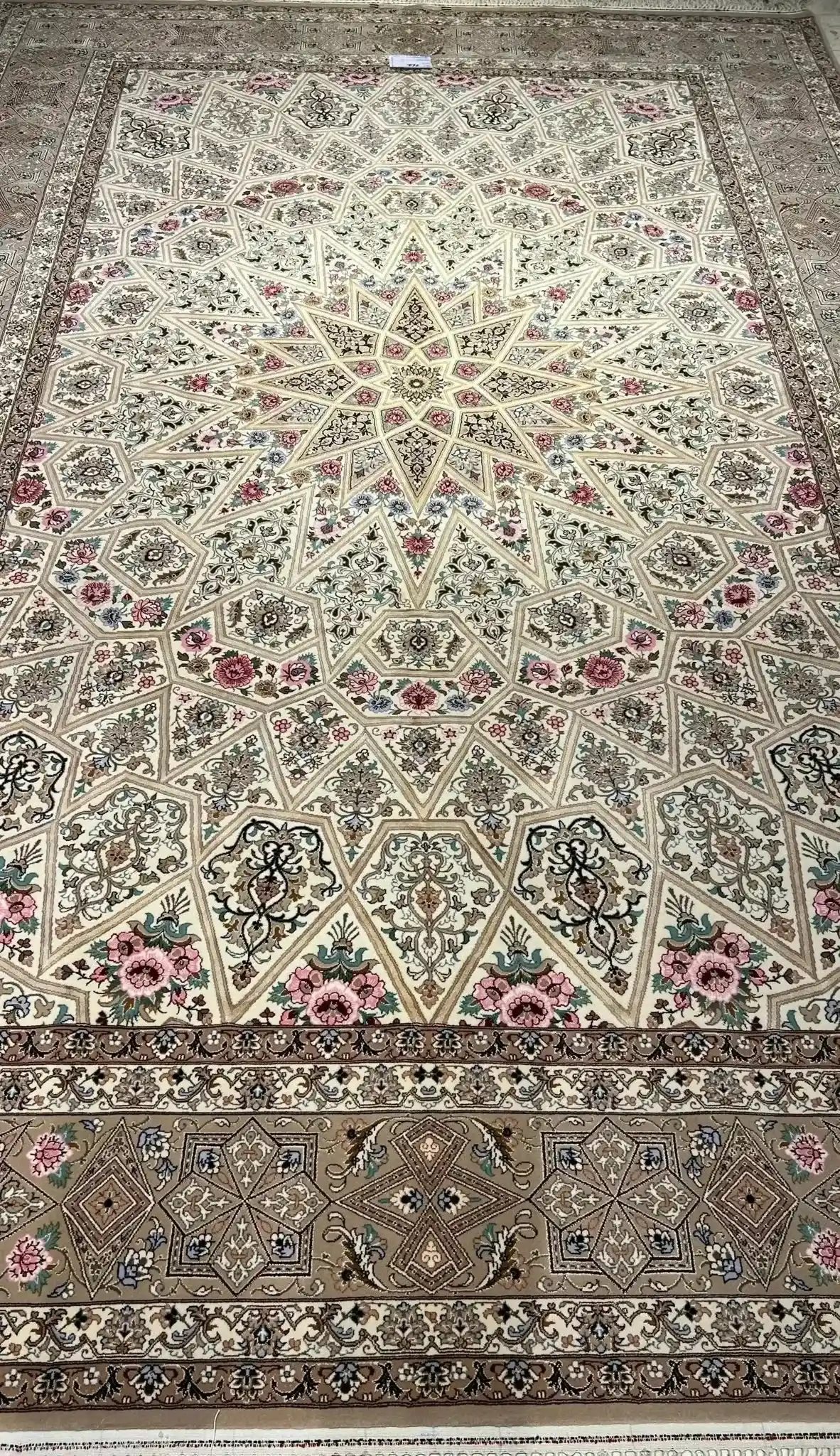 Close-up of the intricate floral patterns on a beige Persian rug