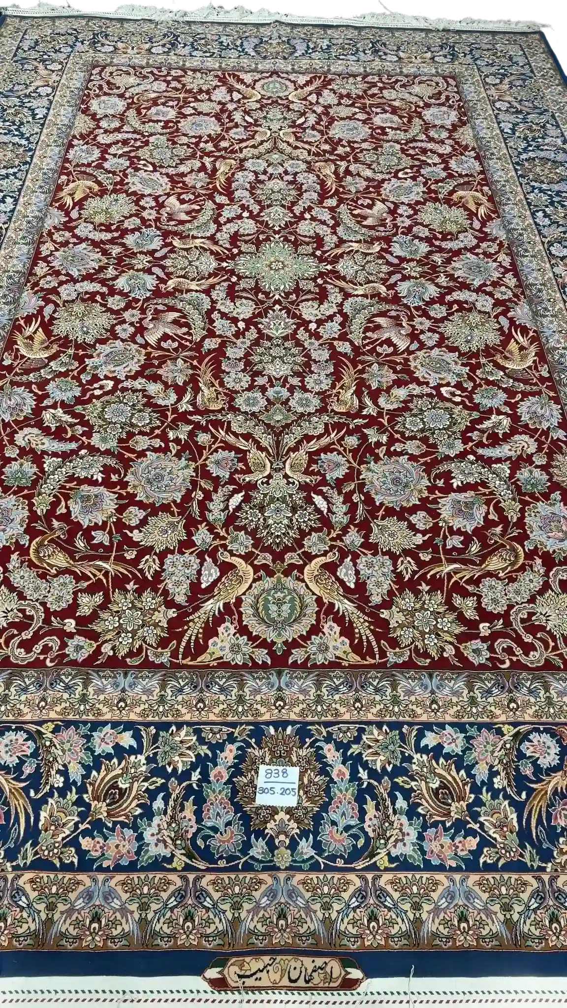 Hand-knotted red and blue Persian rug with intricate floral design
