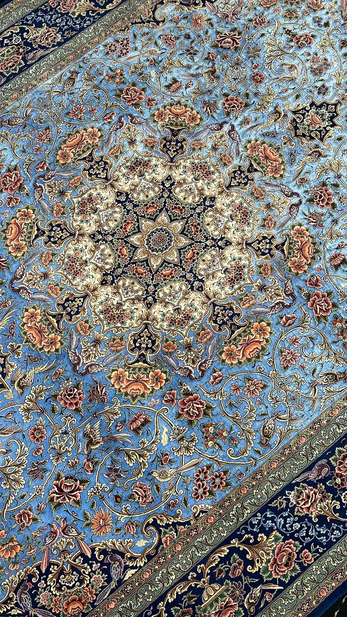 Luxurious blue Iranian carpet with detailed medallion and floral motifs
