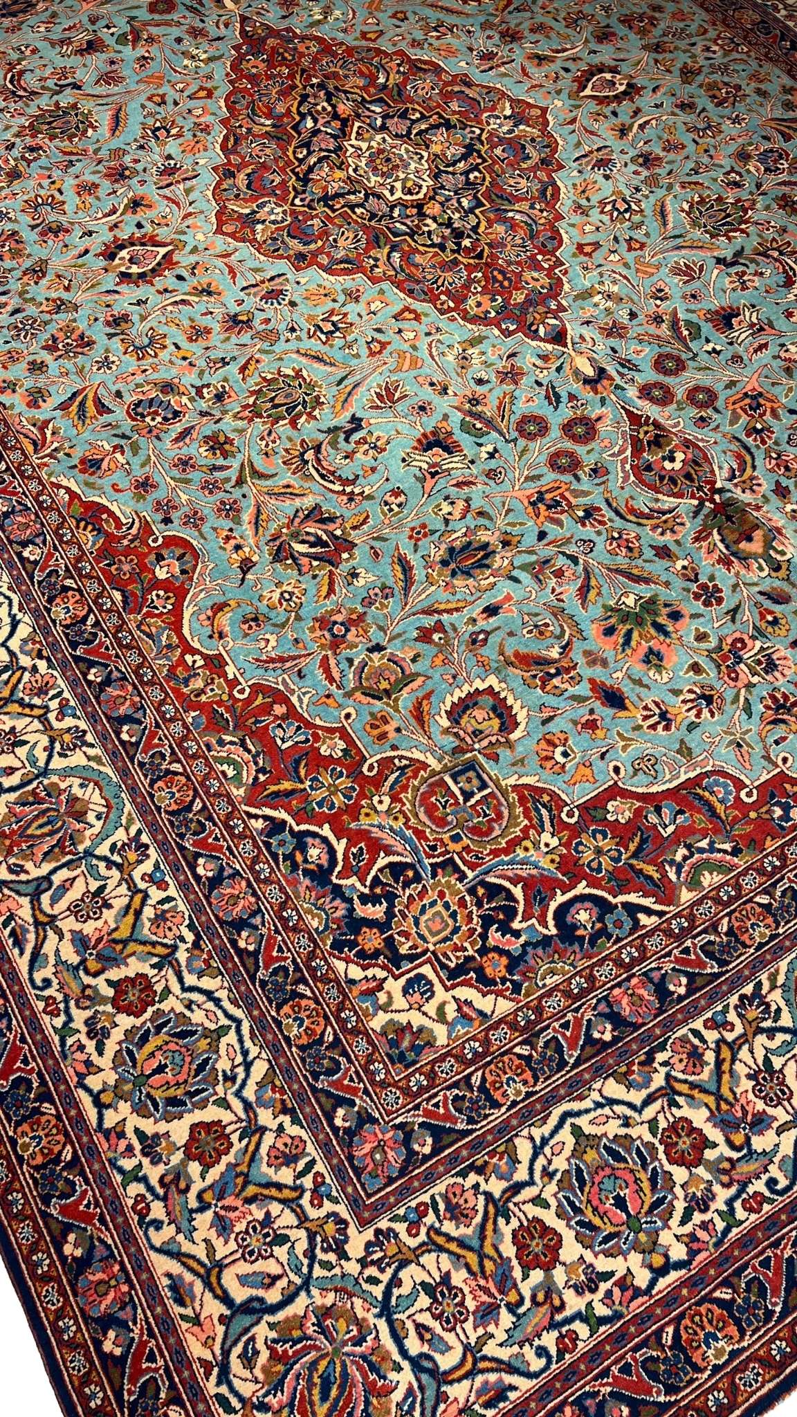 "74-year-old Persian Kashan rug with turquoise and red floral patterns, crafted by Safarzadeh"