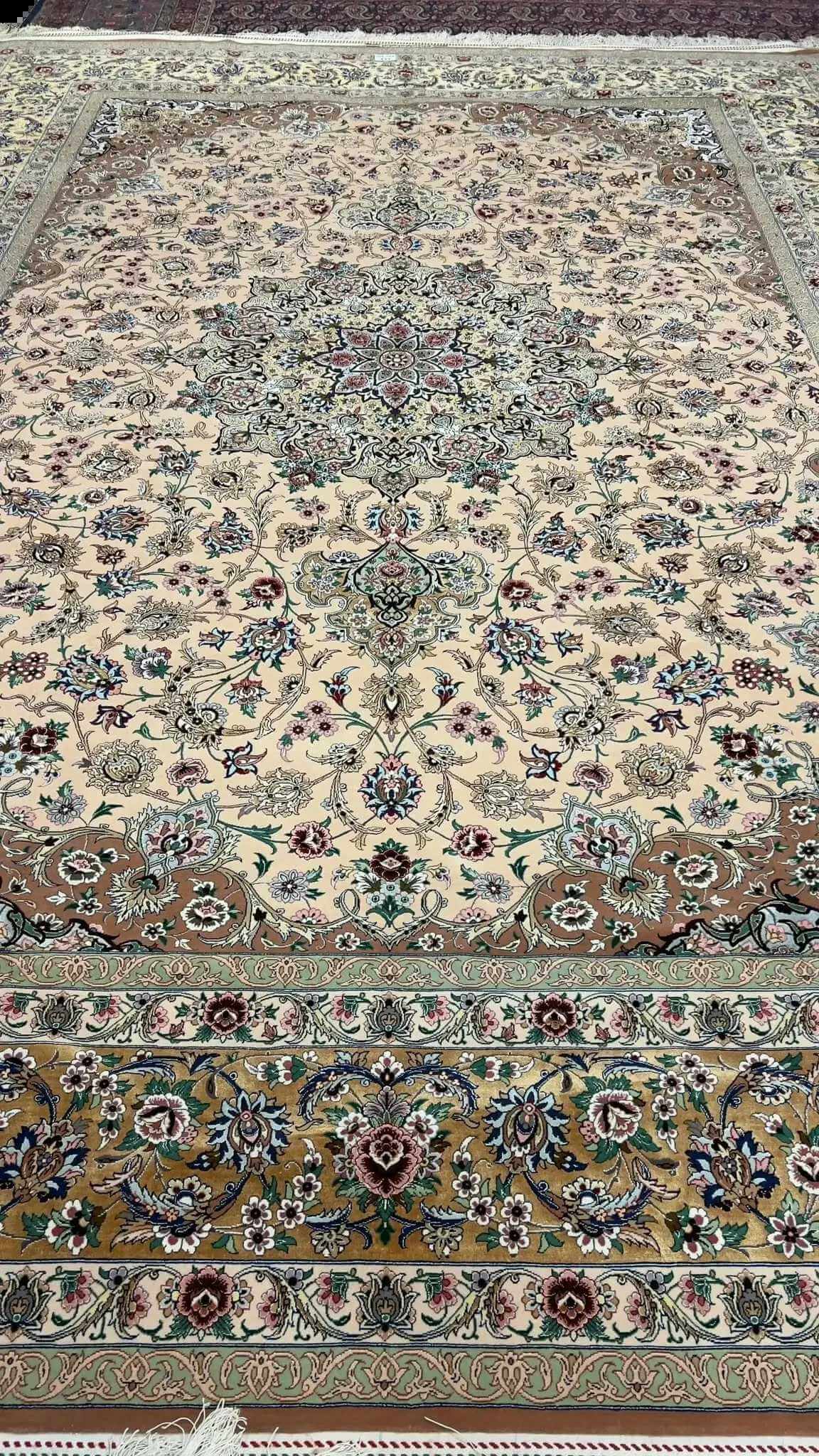 Detailed view of the beige hand-knotted rug from Iran showcasing its floral motifs