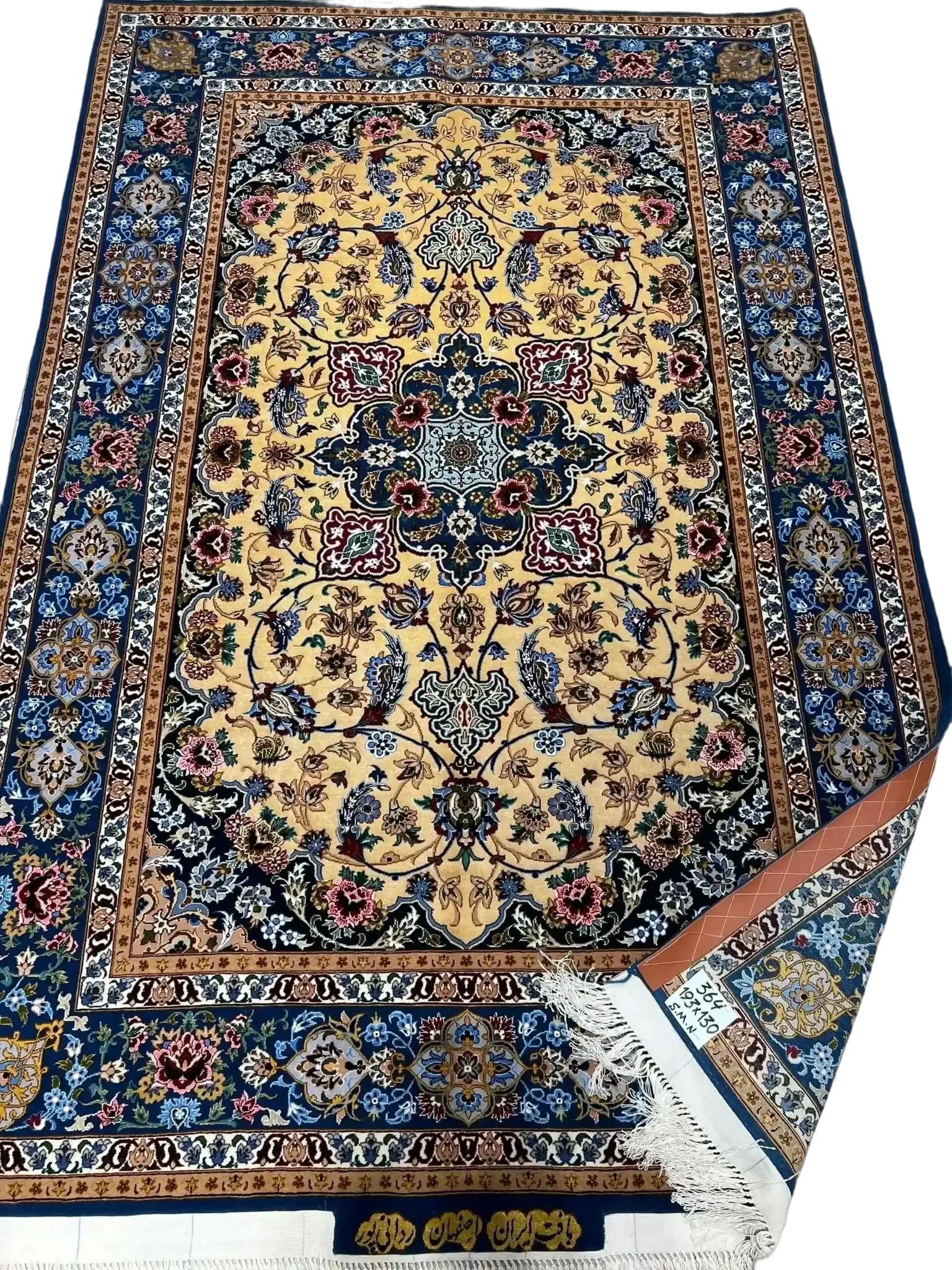 An ornate Isfahan silk carpet featuring blue and gold motifs