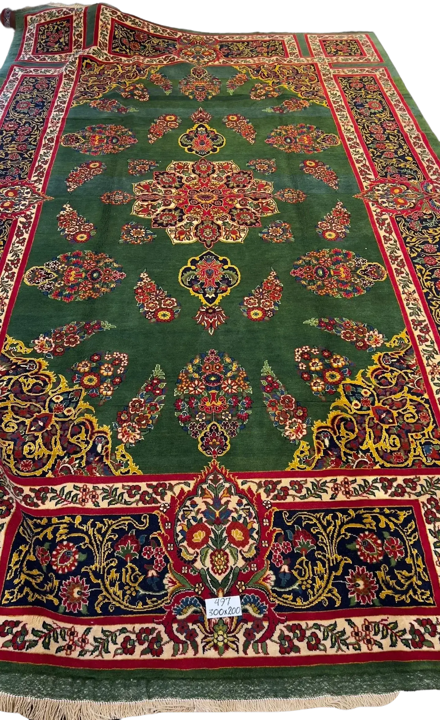 An expansive Mashad rug with intricate patterns and a golden border