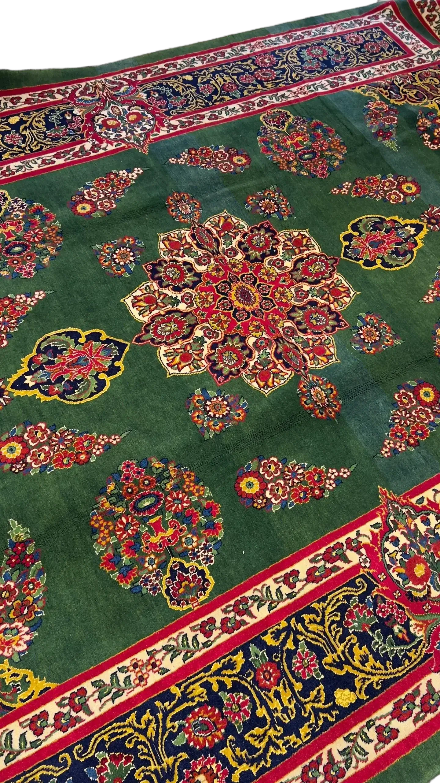 A Mashad rug featuring traditional green and red floral motifs