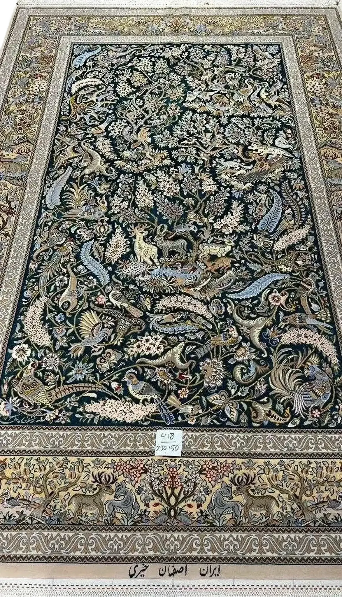 and-knotted Isfahan Persian rug by master weaver Kheire, featuring a detailed wildlife scene with animals and plants. This rug measures 230 cm x 150 cm (approximately 7.5 feet x 4.9 feet) with a thickness of 6 mm and a knot density of 810,000 knots per square meter. It is crafted with a wool and silk pile and a silk warp. This luxurious new rug from Isfahan, Iran, weighs approximately 9 kg and is an exclusive piece, showcasing masterful craftsmanship and intricate natural motifs.