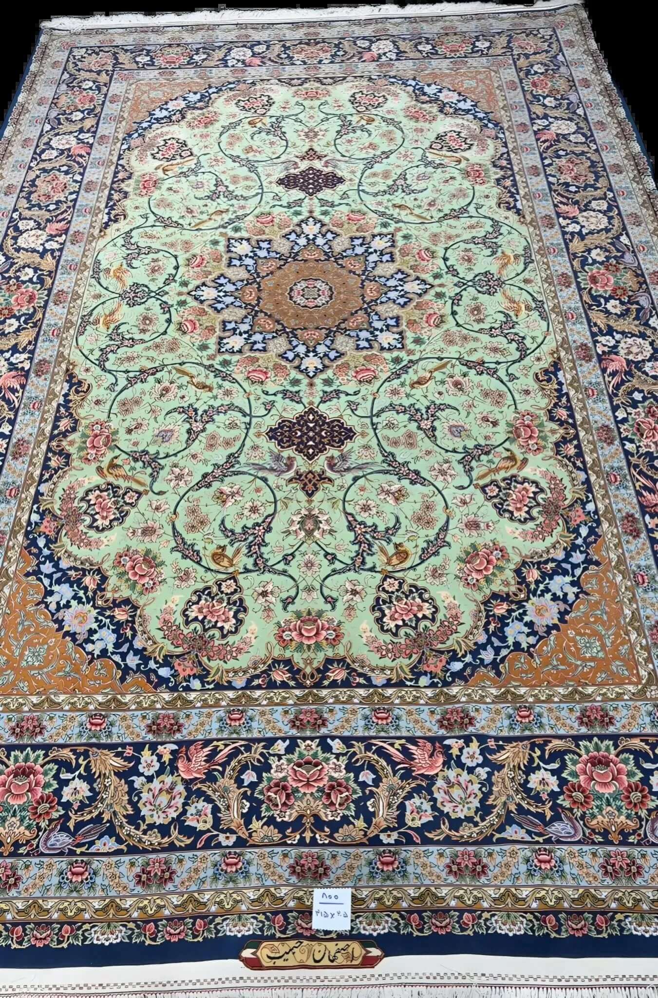 Close-up of the delicate floral patterns on a light green authentic Iranian rug