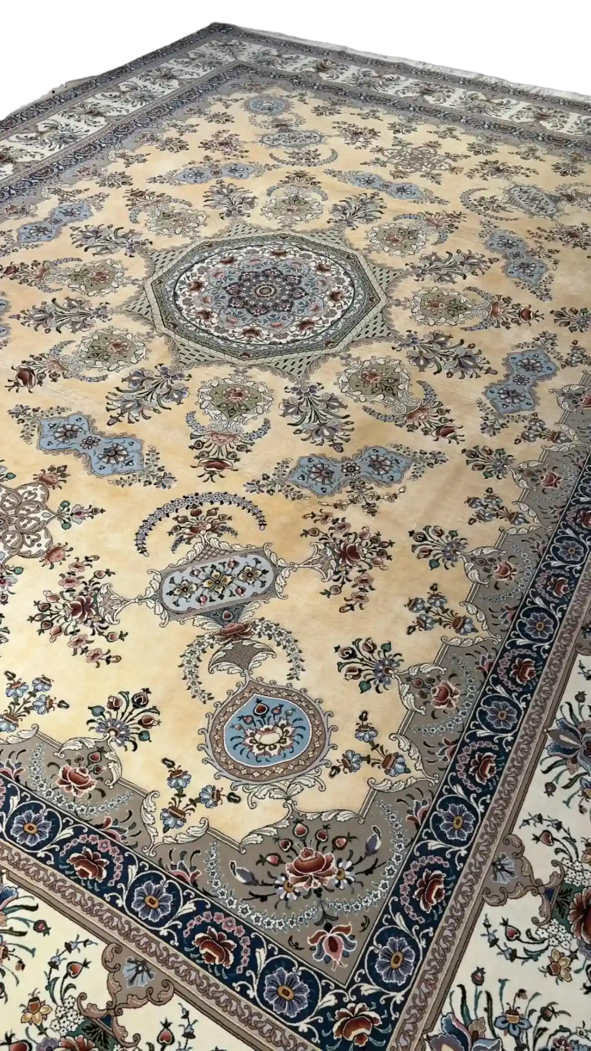 Elegant Persian Isfahan rug in soft beige and blue hues, detailed with a central medallion and bordered with floral motifs.
