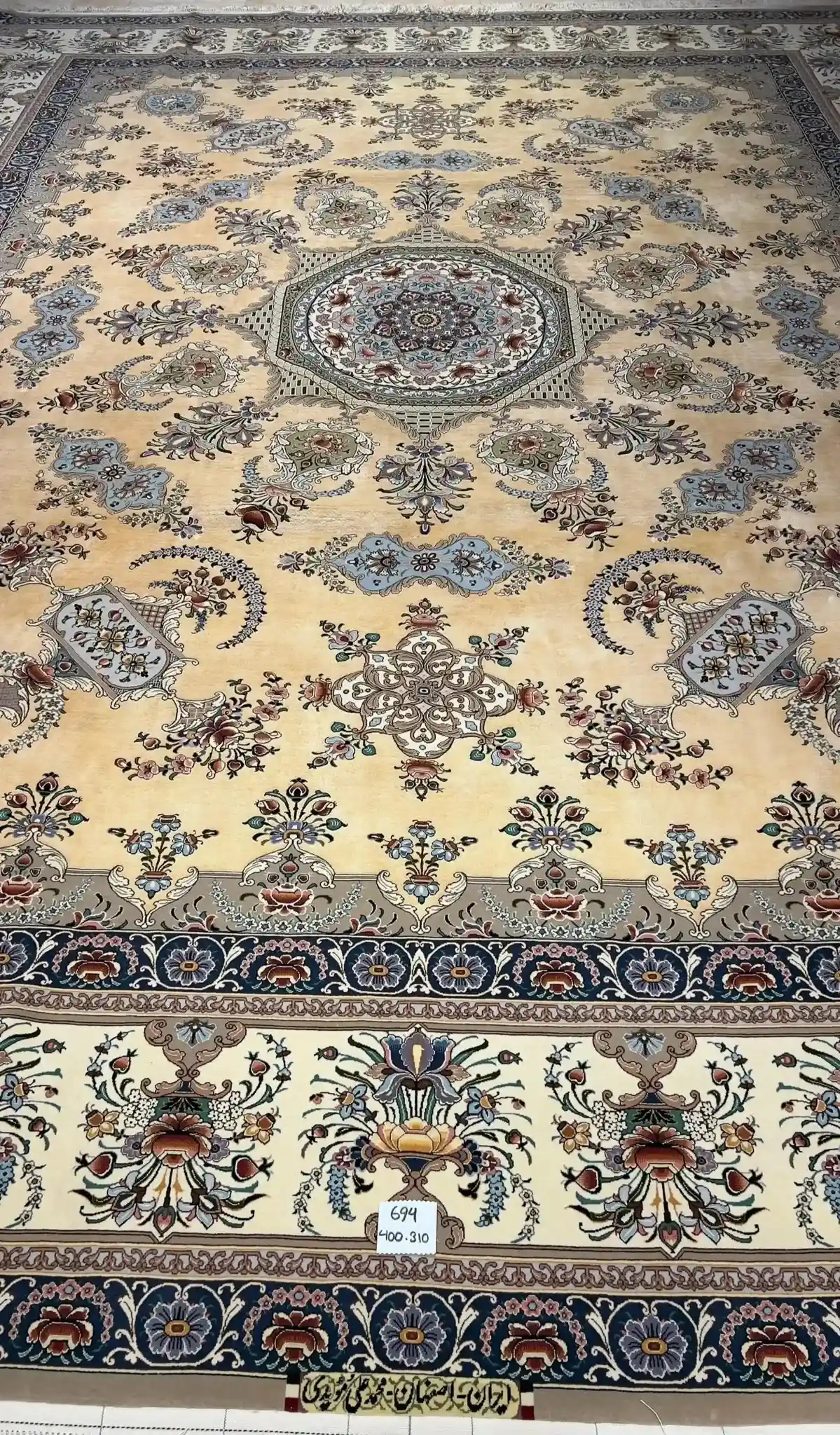 Intricately hand-knotted Isfahan Persian rug with floral medallion pattern in silk and wool, featuring soft neutral tones.
