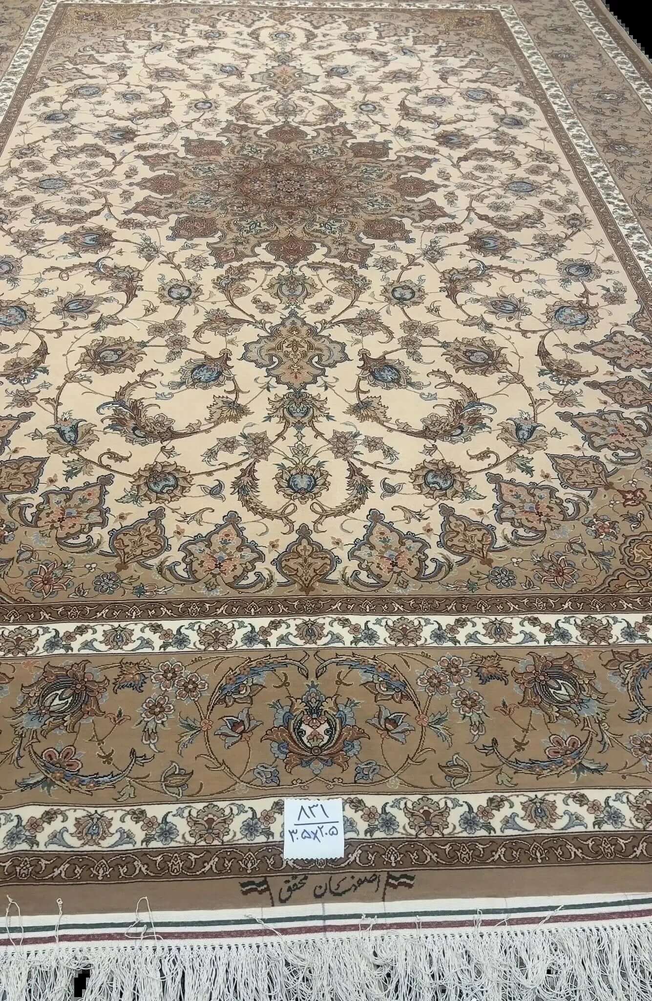 Hand-Knotted Persian Rug by Mohaghegh – 305x205 cm: This hand-knotted Persian rug from Isfahan, featuring a blend of wool and silk in elegant brown and beige tones, is perfect for elevating home interiors. Crafted by master weaver Mohaghegh, it offers luxurious quality and timeless design.

