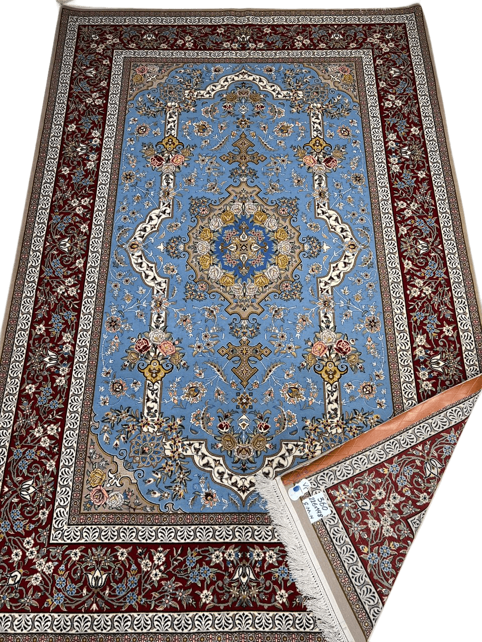 Hand-knotted Isfahan Persian rug featuring a blue central medallion and intricate floral patterns bordered in red and white, woven from wool and silk.
