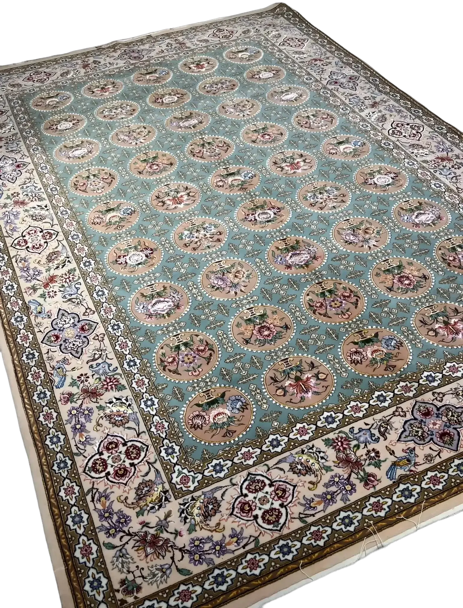 An Isfahan rug featuring intricate blue and green patterns framed by borders